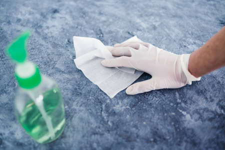 the new normal after covid-19 and life in quarantine, hand using disinfectant wipe and hand sanitizer to clean concrete surface from viruses and bacteriaの写真素材