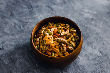 healthy plant-based food recipes concept, vegan nuts and legumes snack mix in wooden bowlの写真素材