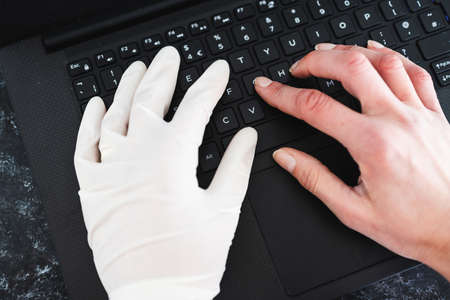 staying safe after the covid-19 virus pandemic outbreak, hand typing on shared computer keyboard at...