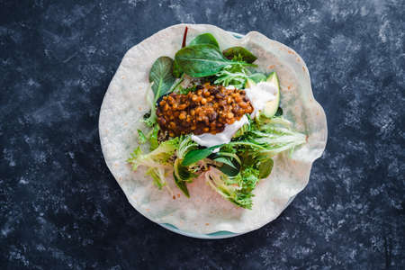 healthy plant-based food recipes concept, vegan healthy open burrito with mixed salad greens mexican bean mix and dairy-free yoghurtの写真素材