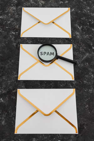 inbox organization and clean-up concept, email envelopes with and without Spam text on them and magnifying glass analyzing themの写真素材