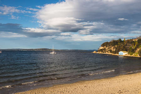 HOBART, TASMANIA - August 1stt, 2020: Blackmans Bay beach on a sunny winter day with few people at...