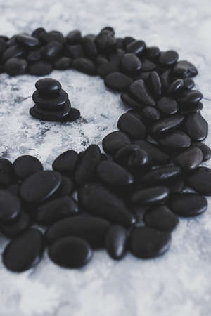 mental health concept, meditation inspired image with zen pebbles stack surrounded by other pebbles...