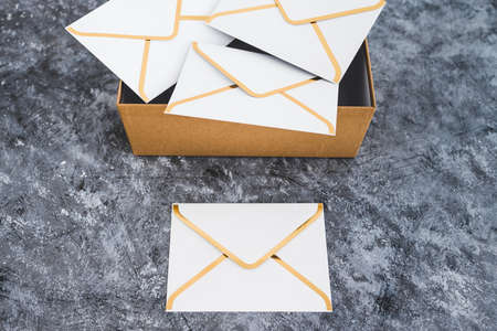 concept of inbox organisation and clean-up, group of envelopes inside box metaphor of email inboxの写真素材