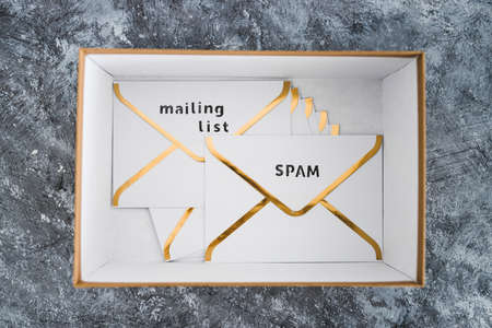 concept of inbox organisation and clean-up, group of envelopes inside box metaphor of email inbox and some marked as spam or mailing list contentの写真素材