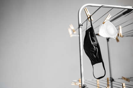 the new normal after the covid-19 virus outbreak and pandemic, different types of face masks hung to dry on clothes airerの写真素材