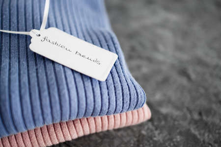 shopping and marketing concept, knit jumpers in alternative colours with Fashion Trends text on...