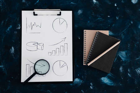 business analysis and statistics concept, desk with mixed graphs and charts on clipboardの写真素材