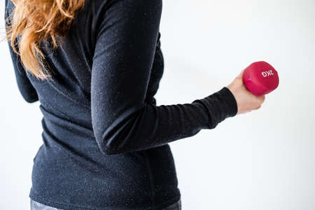 home fitness and online coaching concept, woman in sporty clothes holding dumbbell and exercising...