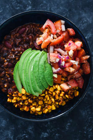 healthy plant-based food recipes concept, vegan mexican style nourish bowl with spicy bean chilli...