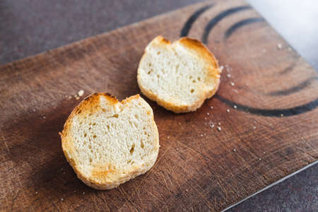 simple food ingredients concept, close-up of fresh bread slices on wooden cutting board