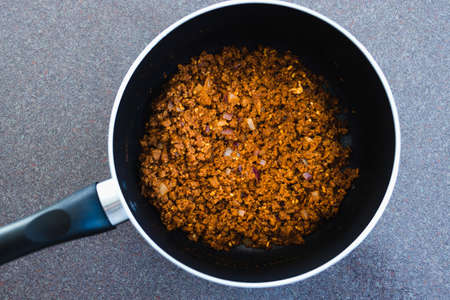 healthy plant-based food recipes concept, vegan rehydrated textured vegetable protein with seasoning before adding tomato sauceの写真素材