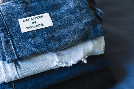tidying up and organizing your wardrobe, Declutter and donate label on different jeans in various denim colorsの写真素材