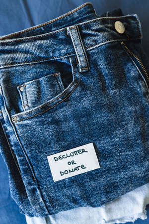 tidying up and organizing your wardrobe, Declutter and donate label on different jeans in various...