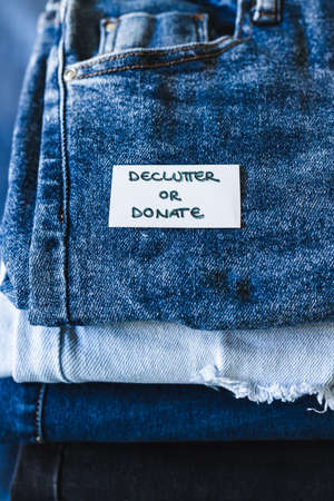 tidying up and organizing your wardrobe, Declutter and donate label on different jeans in various denim colorsの写真素材