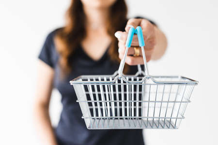 marketing and shopping concept, woman holding shopping cart towards the camera shot at shallow depth of fieldの写真素材