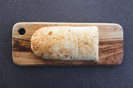 simple food ingredients concept, fresh turkish bread with sesame seeds on cutting board