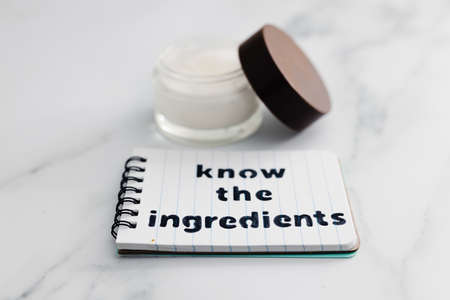 concept of organic and natural beauty products, moisturiser pot with memo saying Know the...
