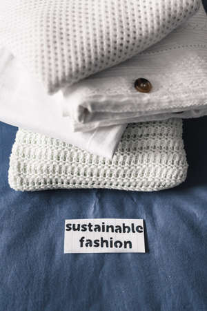 ethical brands and fair trade concept, pile of clothing with Sustainable Fashion labelの写真素材