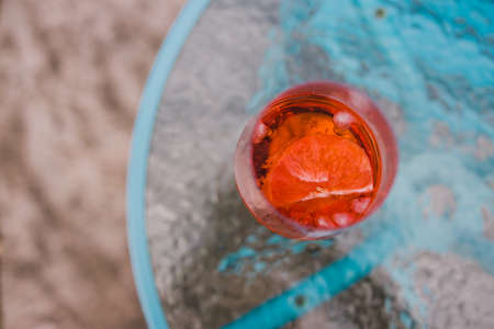drinks and beverages series, with orange liqueur in wine glass with grapefruit slice on outdoor table shot from top down perspective at shallow depth of fieldの写真素材
