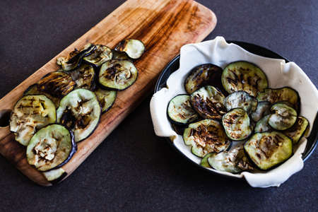 simple food ingredients concept, grilled aubergine slices getting layered into puff pastry pieの写真素材