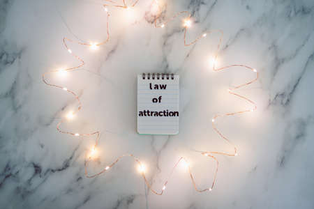law of attraction conceptual image, text on notepad surrounded by fairy lightsの写真素材