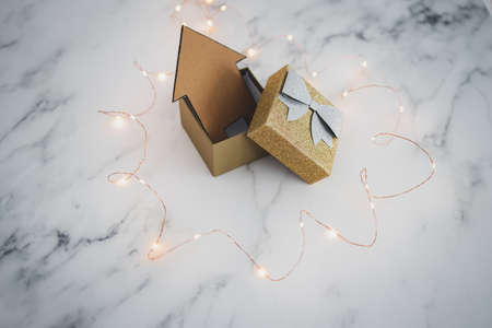 buying or investing in a new house conceptual image, house icon inside of open present box...