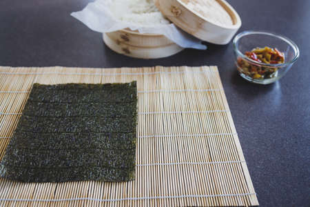 healthy plant-based food recipes concept, homemade vegan sushi with stir fried vegetable filling getting preparedの写真素材