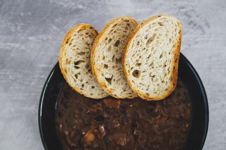 plant-based food, vegan brazilian feijoada with beans and plant-based meats with toasted bread...