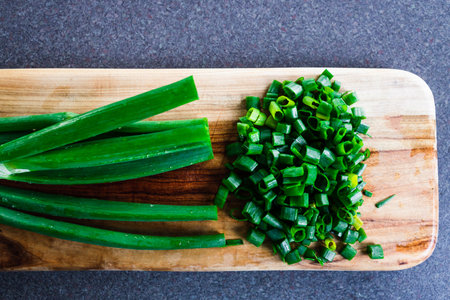simple food ingredients concept, fresh spring onion getting chopped on cuttin boardsの写真素材