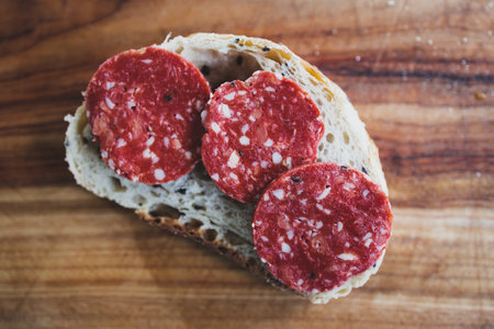 simple food ingredients concept, plant-based salami slices on bread slice on cutting boardの写真素材
