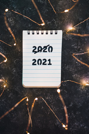 festive fairy lights with text 2020 crossed out and 2021 underneath, concept of facing the challenges caused by the outbreak of the covid-19 virusの写真素材