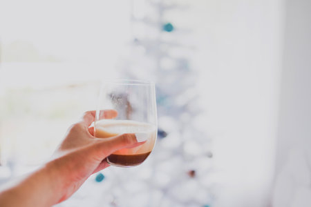 cheering with espresso martinis with Christmas tree bokeh in the background shot at shallow depth of...