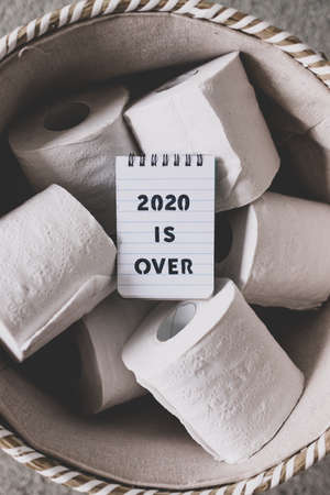 basket full of toilet paper rolls with memo saying 2020 is over, concept of facing the challenges caused by the outbreakの写真素材