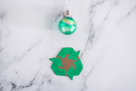 ecology and green ideas for the environment conceptual image, green light bulb next to recycle logo made of cardboardの写真素材
