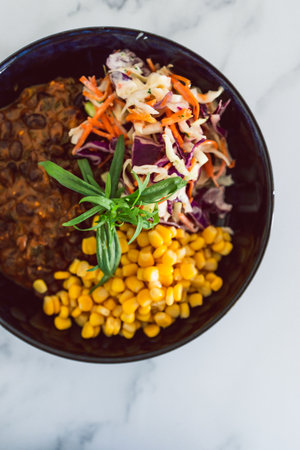healthy plant-based food recipes concept, vegan nourish bowl with mexican beans corn avocado and dairy-free coleslaw salad mixの写真素材