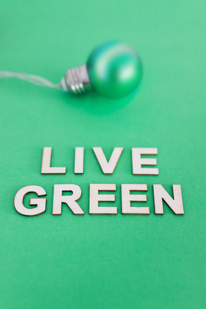 ecology and sustainability, green light bulb with Live Green text on tone on tone backgroundの写真素材