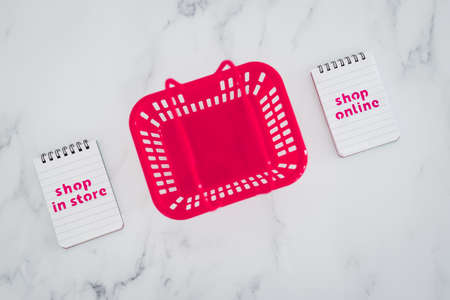 competition and retail industry conceptual image, pink shopping baskets with shop in store vs shop...