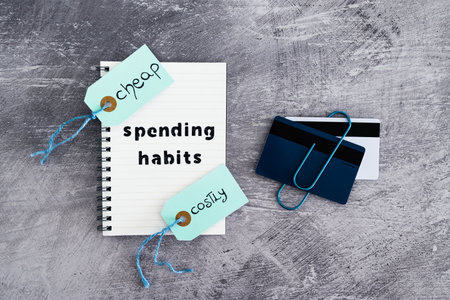 spending habits text on notepad with payment cards and Cheap vs Costly prioduct price tags next to it, money and consumer behaviour conceptual imageの写真素材