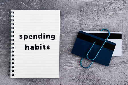 spending habits text on notepad with payment cards next to it, money and consumer behaviour conceptual imageの写真素材