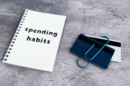 spending habits text on notepad with payment cards next to it, money and consumer behaviour conceptual imageの写真素材