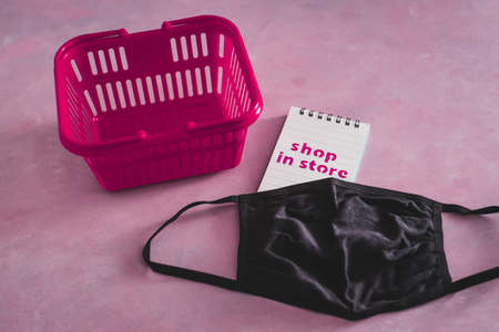 shop in store text with face mask and shopping basket, competition and retail industry recovery after the pandemic conceptual imageの写真素材