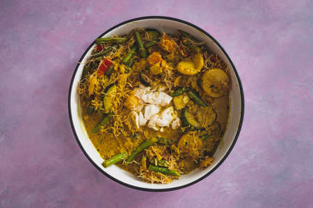 vegan yellow curry with mixed vegetables tofu and vermicelli noodles, healthy plant-based food recipesの写真素材