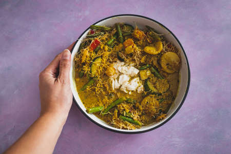 vegan yellow curry with mixed vegetables tofu and vermicelli noodles, healthy plant-based food recipesの写真素材