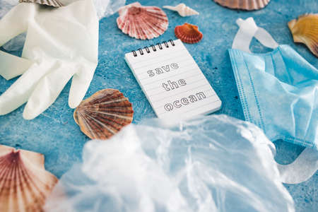 save the ocean text on blue bakground with sea shells and plastic garbage symbol of environmental...