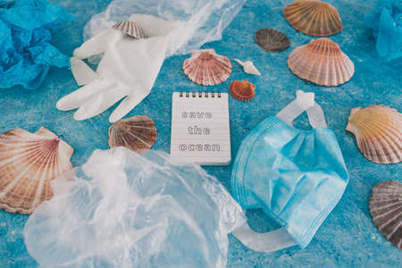 save the ocean text on blue bakground with sea shells and plastic garbage symbol of environmental...