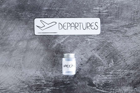 air travel during the  pandemic conceptual image, airport style Departures sign with vaccine next to itの写真素材