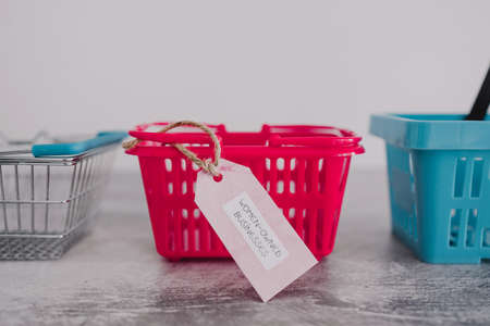 women-owned businesses tag with pink shopping basket among competitor blue ones, supporting equality and equal opportunitiesの写真素材