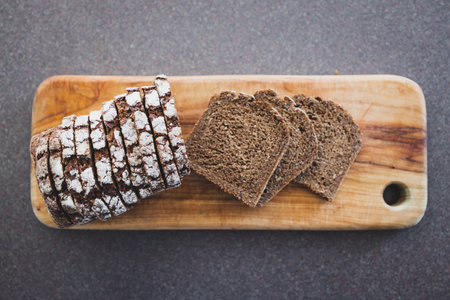 fresh loaf of sliced German rye bread on cutting board, concept of simple natural healthy...