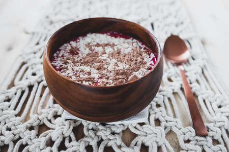 vegan smoothie bowl with raspberry vanilla oat milk smoothie topped with cocoa and coconut flakes, healthy plant-based food conceptの写真素材